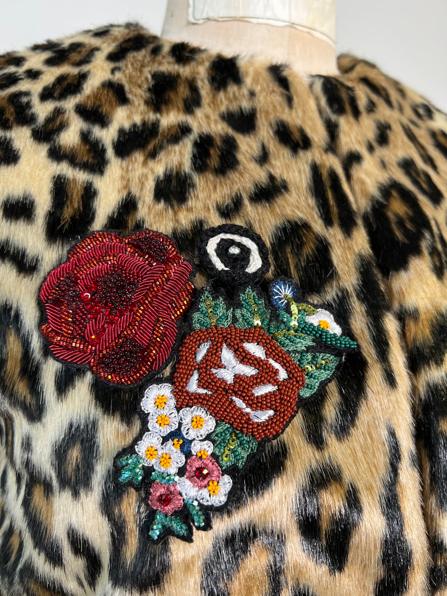 Veste sans manches en fausse fourrure léopard à applique florale (S/M)